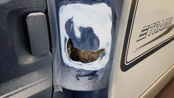 Freigelegte Öffnung in der blauen Wohnmobilverkleidung hinter der Fahrertür